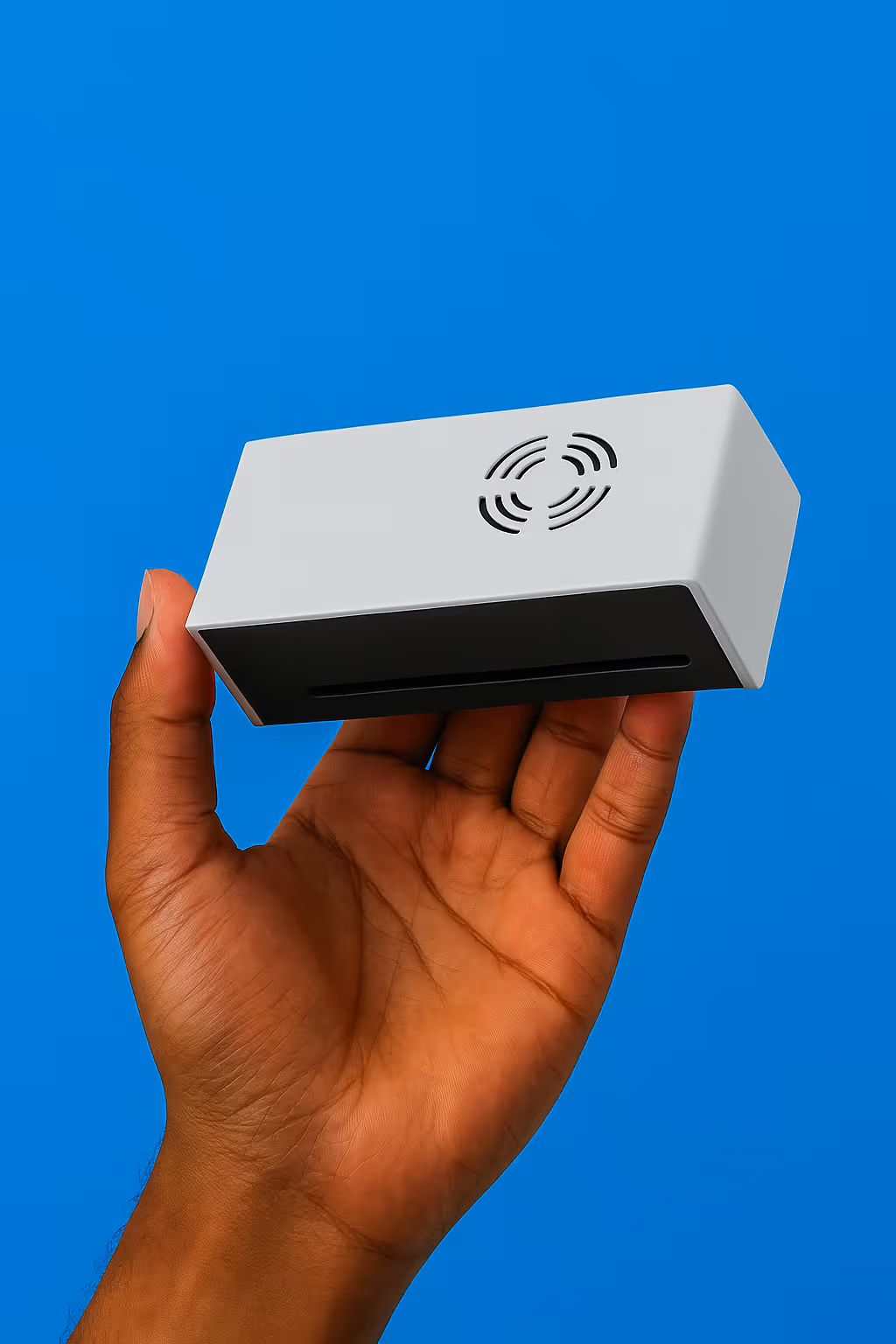 A hand holding a white box with a blue sky in the background.