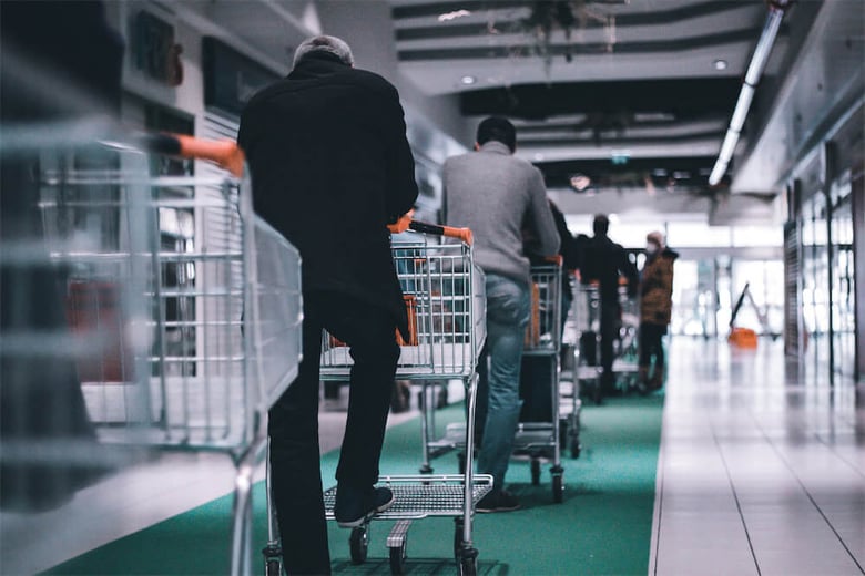 Shoppers with trolleys waiting in line